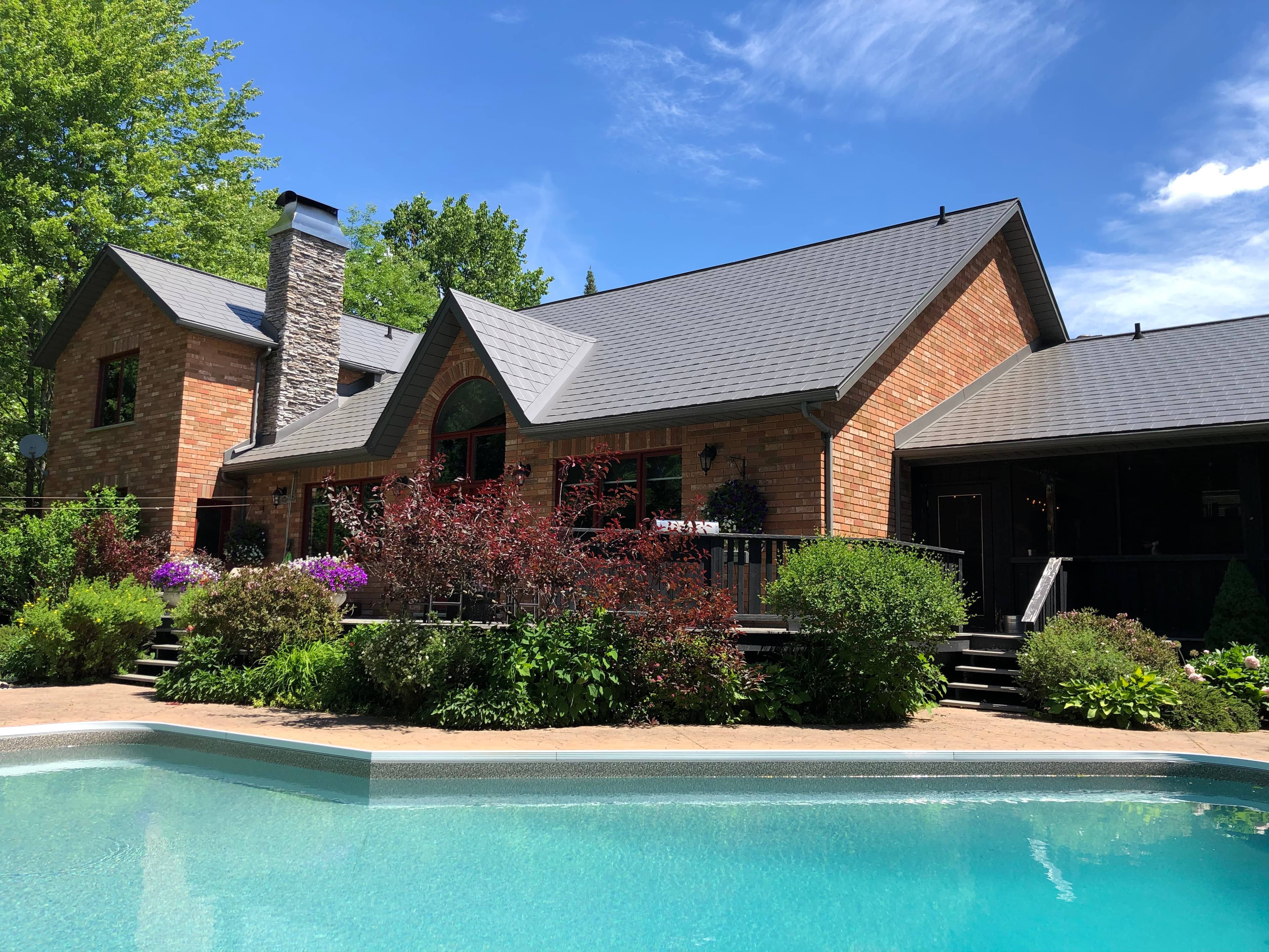 Brick home with metal roof, poolside elevation
