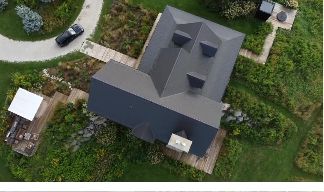 Overhead of a finished Wakefield Bridge steel-shingle roof in Mansfield, Mulmur — gables, dormers, and a chimney